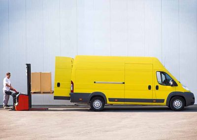 Pracovník nakladá tovar do žltého nákladného auta, aj vďaka rýchlej pôžičke pre živnostníkov